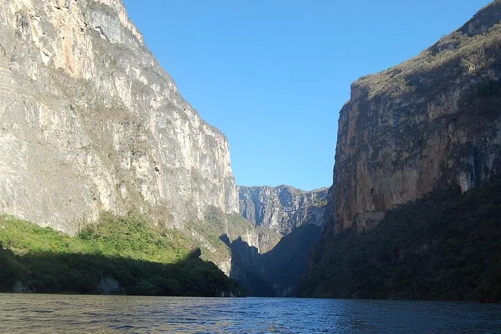 Sunlight illuminating the sheer canyon walls rising from the river at Sumidero Canyon